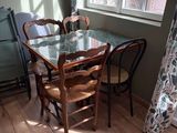 une table et des chaises en verre dans une pièce dotée d'une fenêtre