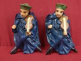 deux figurines représentant un homme et une femme assis sur une surface rouge