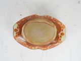 an orange and white bowl on a white table