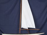 une maquette de voilier avec une voile blanche