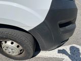 a white van parked in a parking lot next to a parking meter