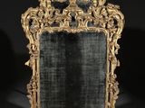 un miroir richement sculpté, doté d'un cadre doré et d'un fond noir