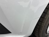 the front bumper of a white car with scratches on it