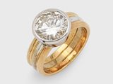 un gros plan d'une bague sertie d'un diamant sur fond blanc
