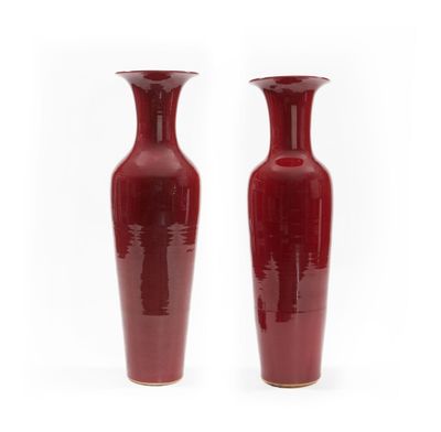 deux vases rouges posés côte à côte sur une surface blanche