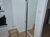 a coat rack in the corner of a room with a mirror
