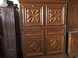 une armoire en bois sur laquelle est posé un chat