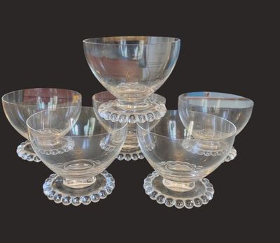 six clear glass bowls and cups are sitting on a table