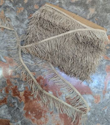 a straw bag with a fringe on it sitting on a table