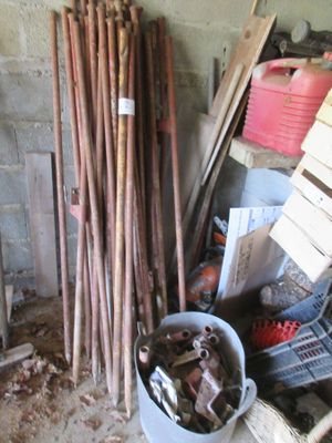 un seau rempli d'outils posé à côté d'un tas de bois