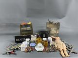 a doll sitting next to a pile of assorted items