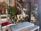 a statue of a man riding a horse in a living room