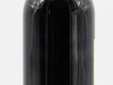a black bottle with a red cap sitting on a white surface