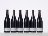 six bottles of wine lined up in a row on a table