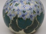 un vase bleu et blanc orné de fleurs bleues