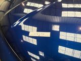 a blue car with a sticker on it ' s hood