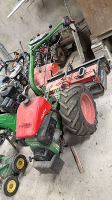 un tracteur vert et un tracteur rouge par terre