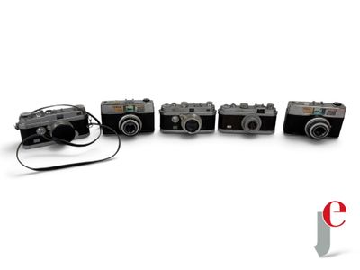four cameras sitting next to each other on a white surface