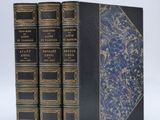 three books are stacked on top of each other on a white surface