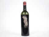 une vieille bouteille de vin posée sur une surface blanche