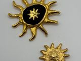 two gold and black enamel sun and star brooches