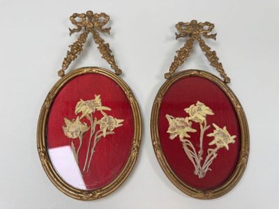 une paire de cadres ovales rouges et dorés ornés de fleurs