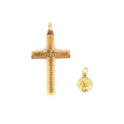 un gros plan d'une croix et d'une breloque en or sur fond blanc