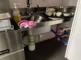 a kitchen with a sink, dishwasher, and other items on the counter