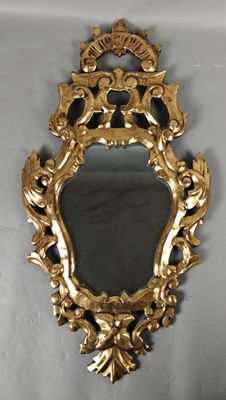 an image of a gold framed mirror hanging on a wall