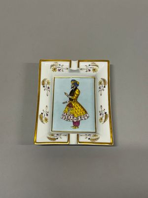 une image représentant une petite assiette sur laquelle figure une femme en robe jaune