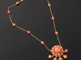 a necklace with coral beads and a gold chain