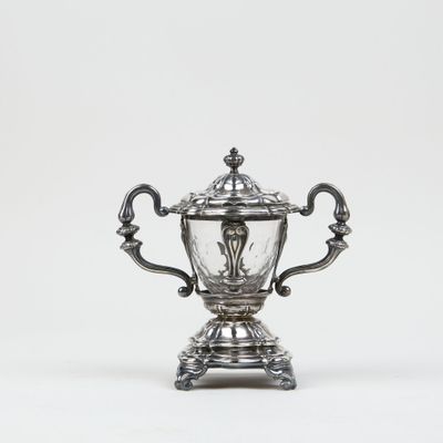 an antique silver plated trophy on a stand on a white background