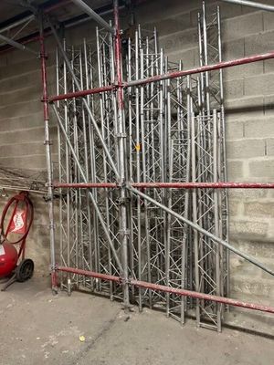scaffolding on the side of a building next to a red cart
