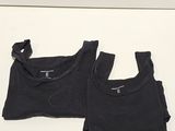 two black t - shirts on a white surface with a white background