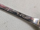 a silver spoon with a heart on it on a table