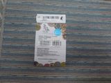 a picture of a price tag on a blue and green striped fabric