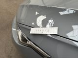 a sticker on the hood of a car that is parked in a parking lot