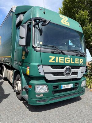 un camion vert garé sur le bord de la route