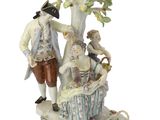 une figurine représentant un homme et une femme assis sous un arbre