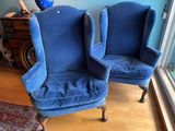 pair of blue upholstered chairs in front of a window in a living room