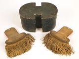 une paire de brosses en bois à franges posées sur une surface blanche