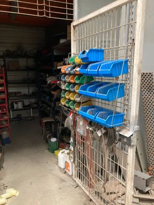 un rayonnage métallique sur lequel sont posés des bacs en plastique, dans un garage