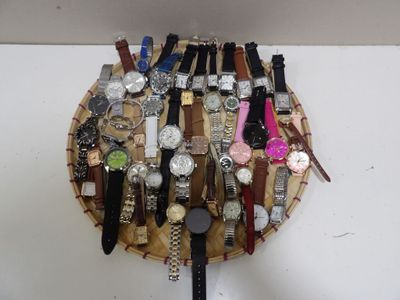 de nombreuses montres posées sur un plateau en bois