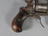 a small revolver with a wooden handle on a white surface