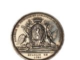 une image représentant une pièce d'argent sur laquelle figure un blason