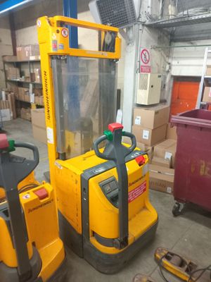 a yellow forklift in a warehouse with boxes in the background