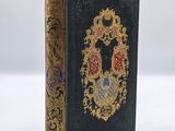 a black book with gold trimming and a decorative design