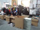 une pièce remplie de vêtements et de cartons dans un magasin