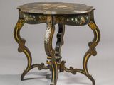 an antique table with a black and gold design on it