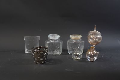 five different glass vases on a table with a black background